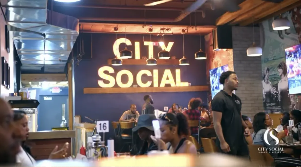 Guests dining beneath the illuminated City Social sign